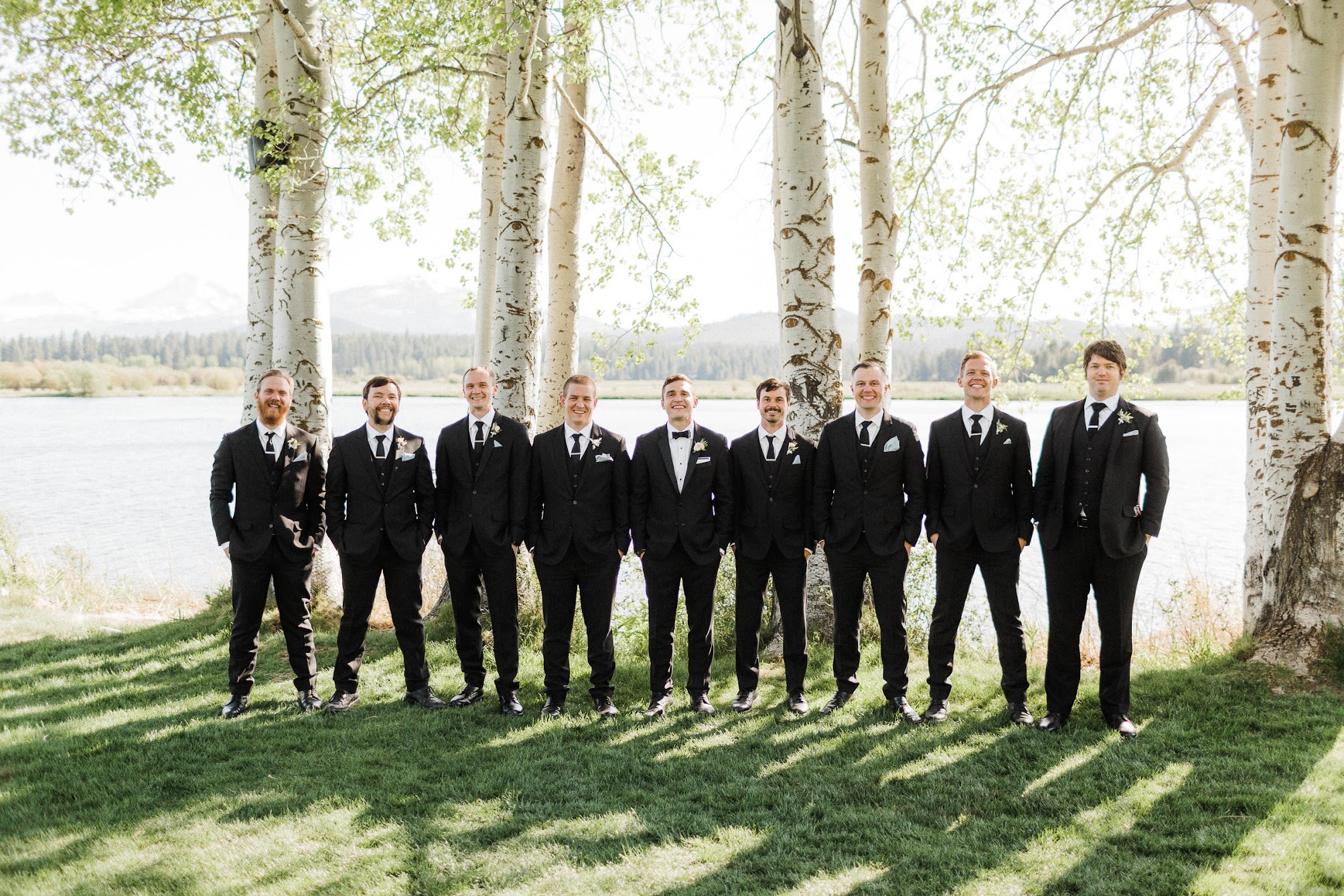 all the groomsmen in a line outside on the grass