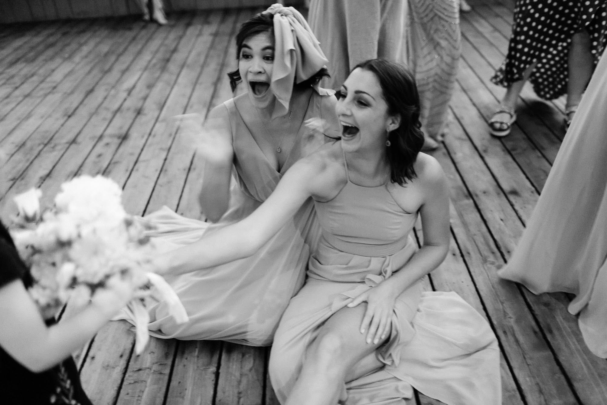 two bridesmaids on the floor laughing 