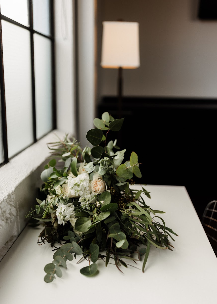 floral bouquet with lots of greenery, laying on a desk