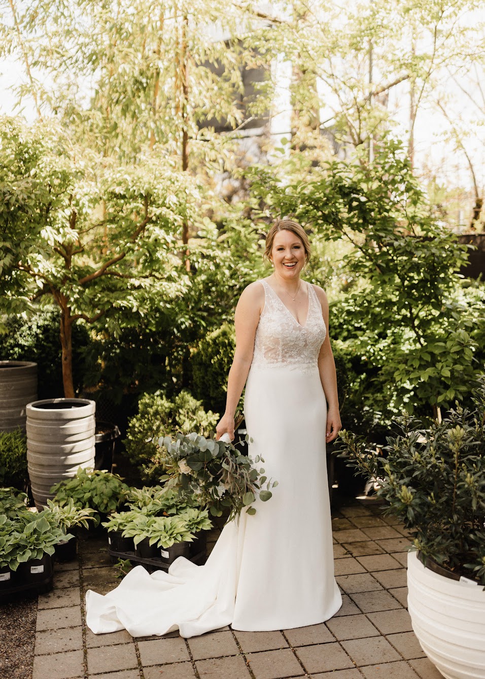 bride holding her bouquet while she stands in garden 