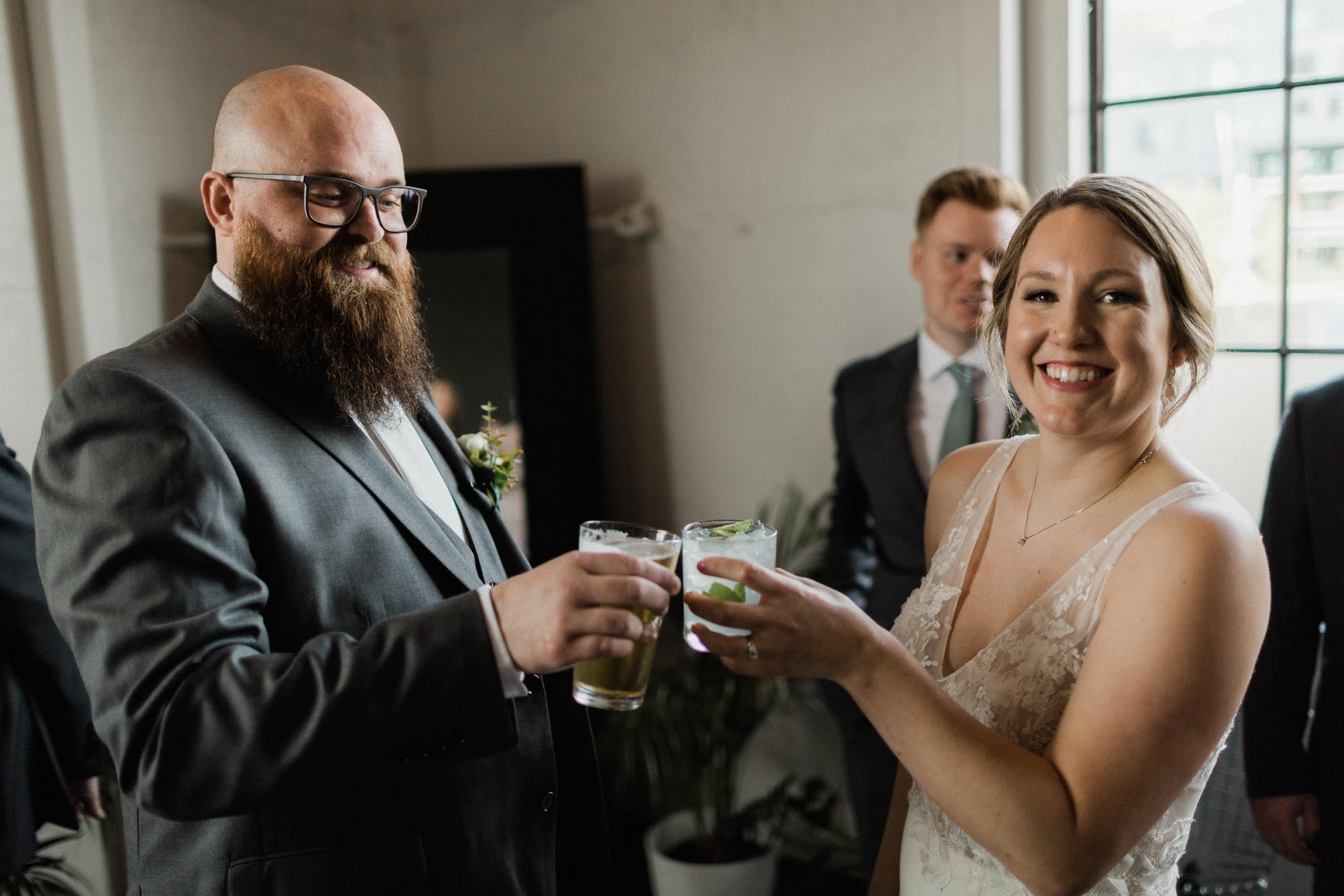 bride and grooms holding drinks up 