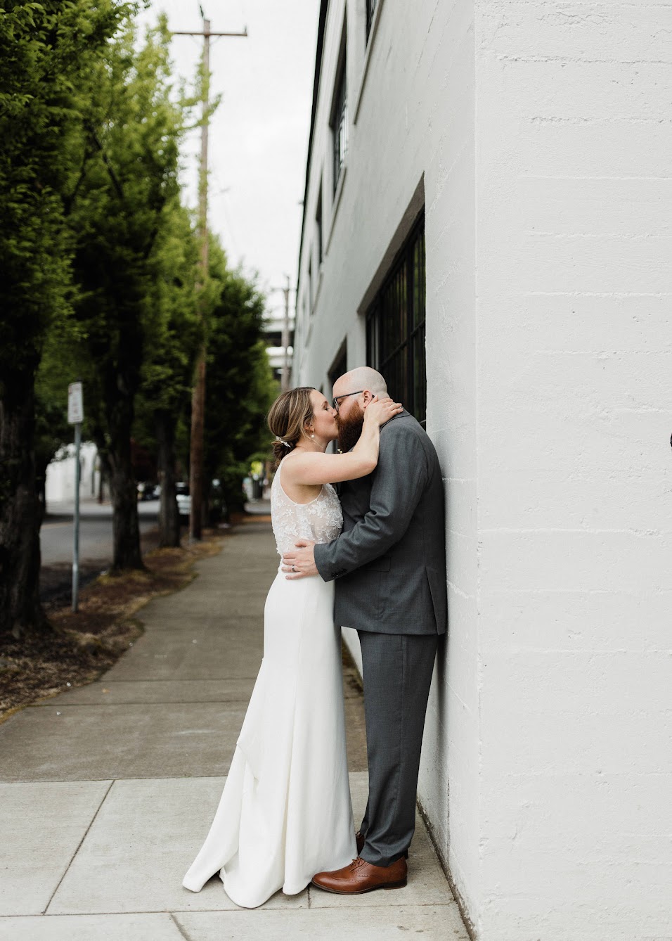 bride and groom kissing on the side of the street