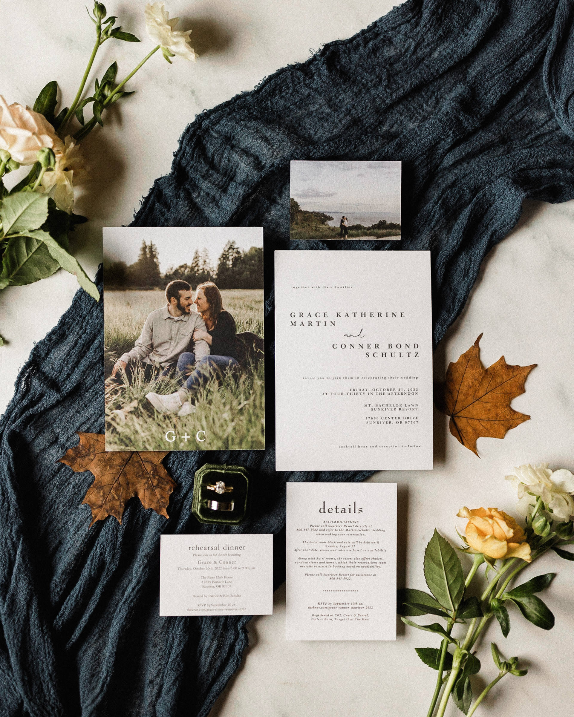 Invitation suite for a Sunriver Resort wedding styled with wedding bands, blue thule, flowers, and fall leaves
