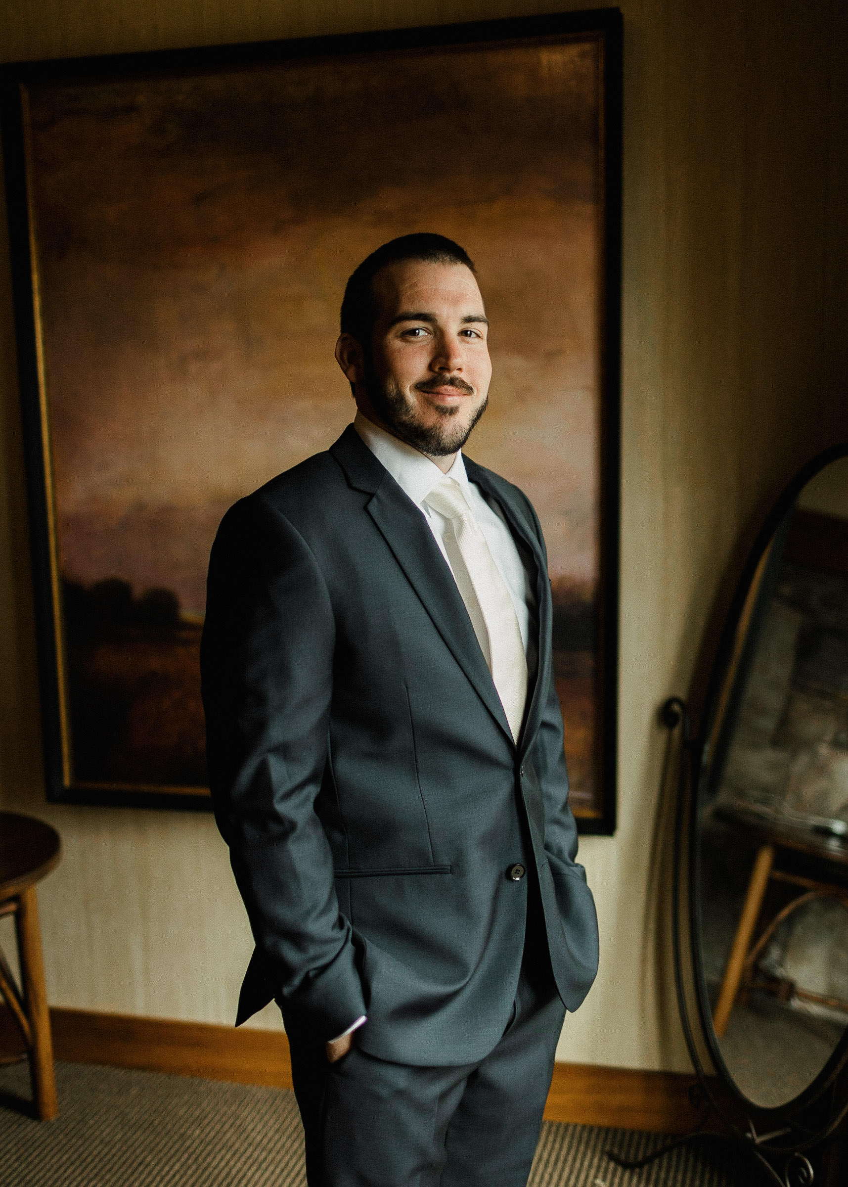 Groom poses for a portrait in a Sunriver Resort suite