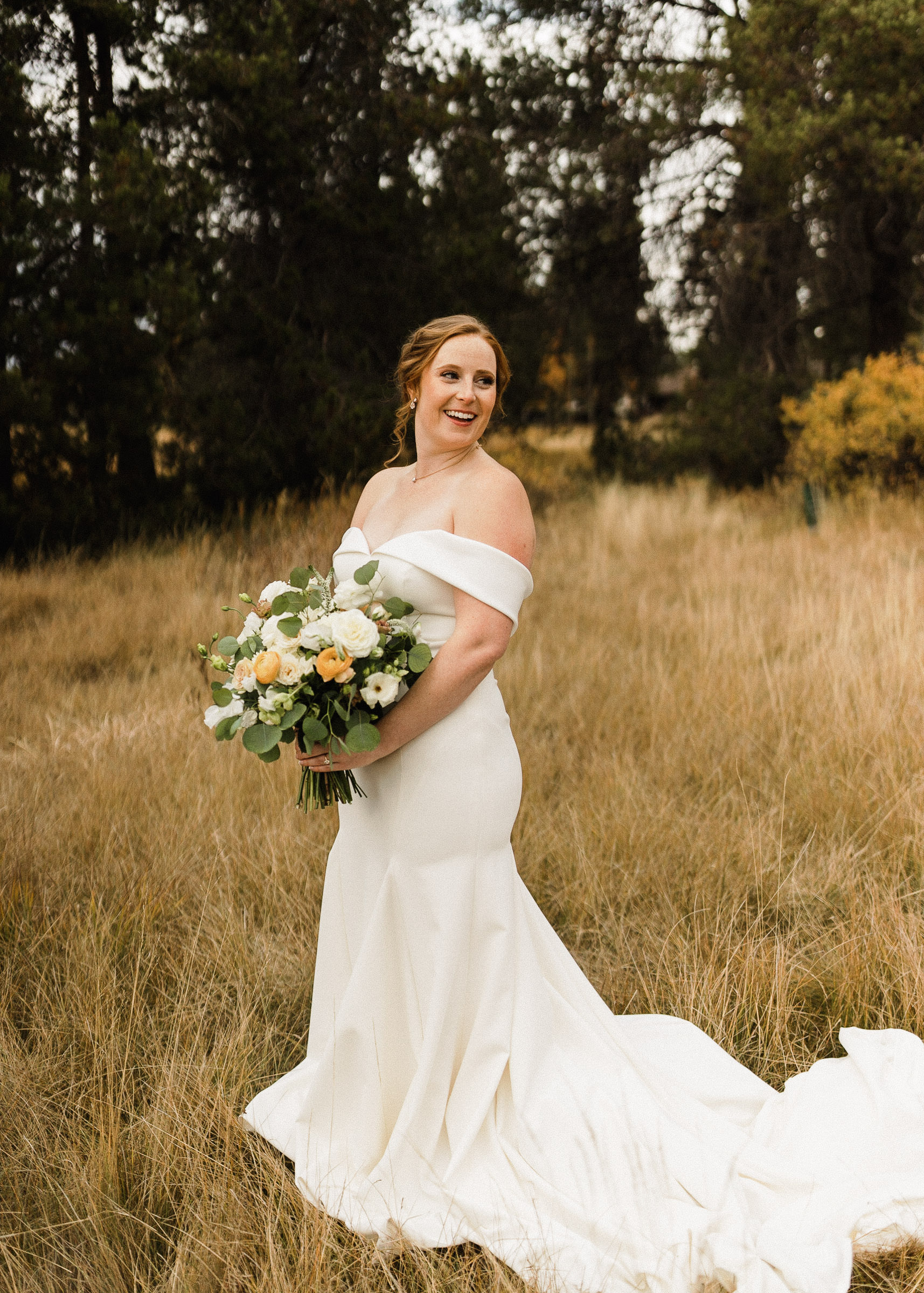 Bride poses for portraits in a field at Sunriver Resort