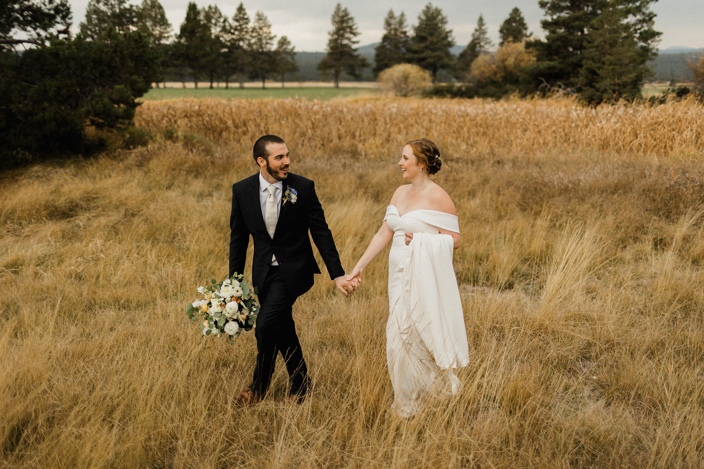 Bride and groom pose for portraits in a field at Sunriver Resort