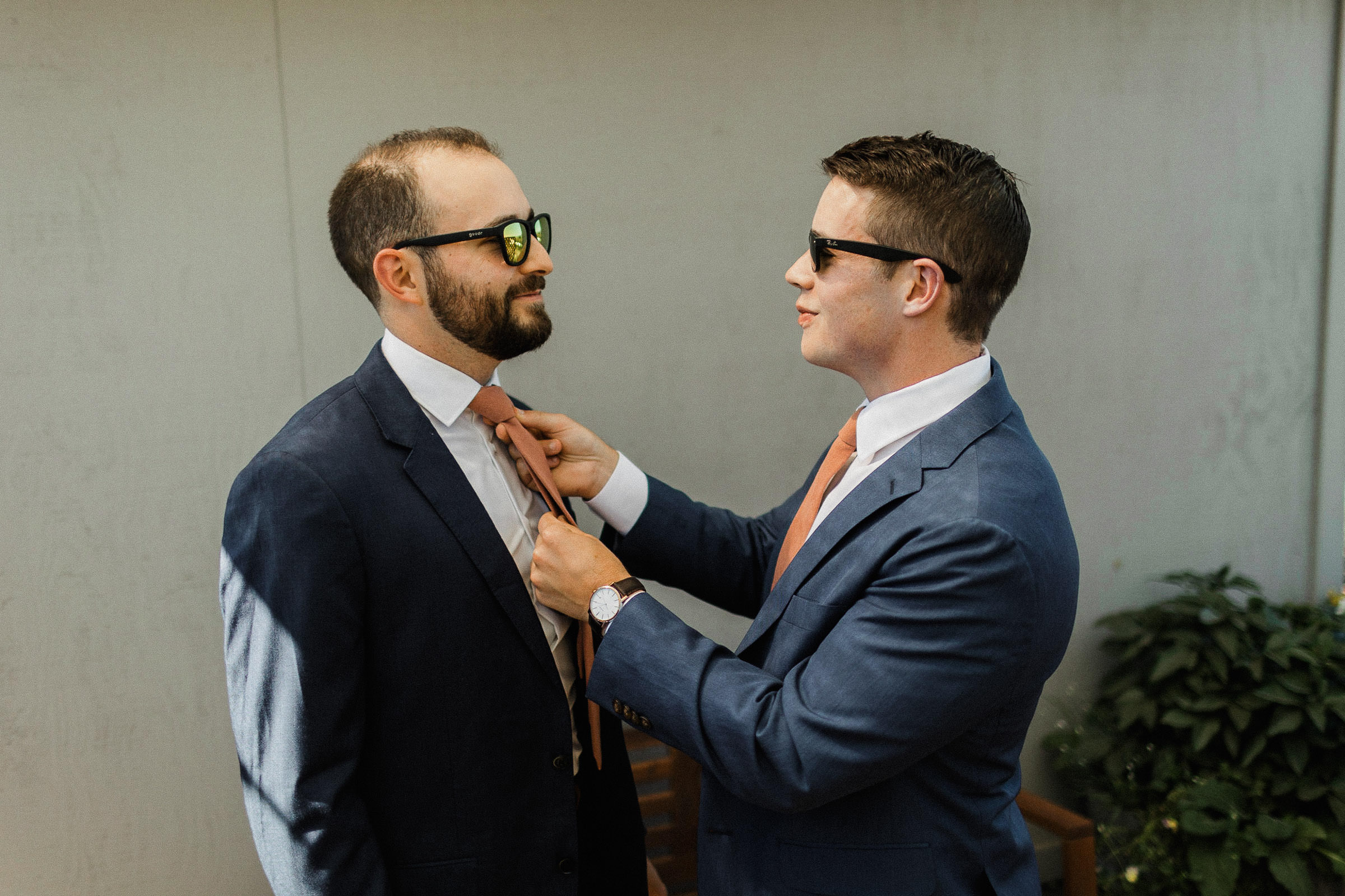 Groom straightens the necktie of one of his groomsmen