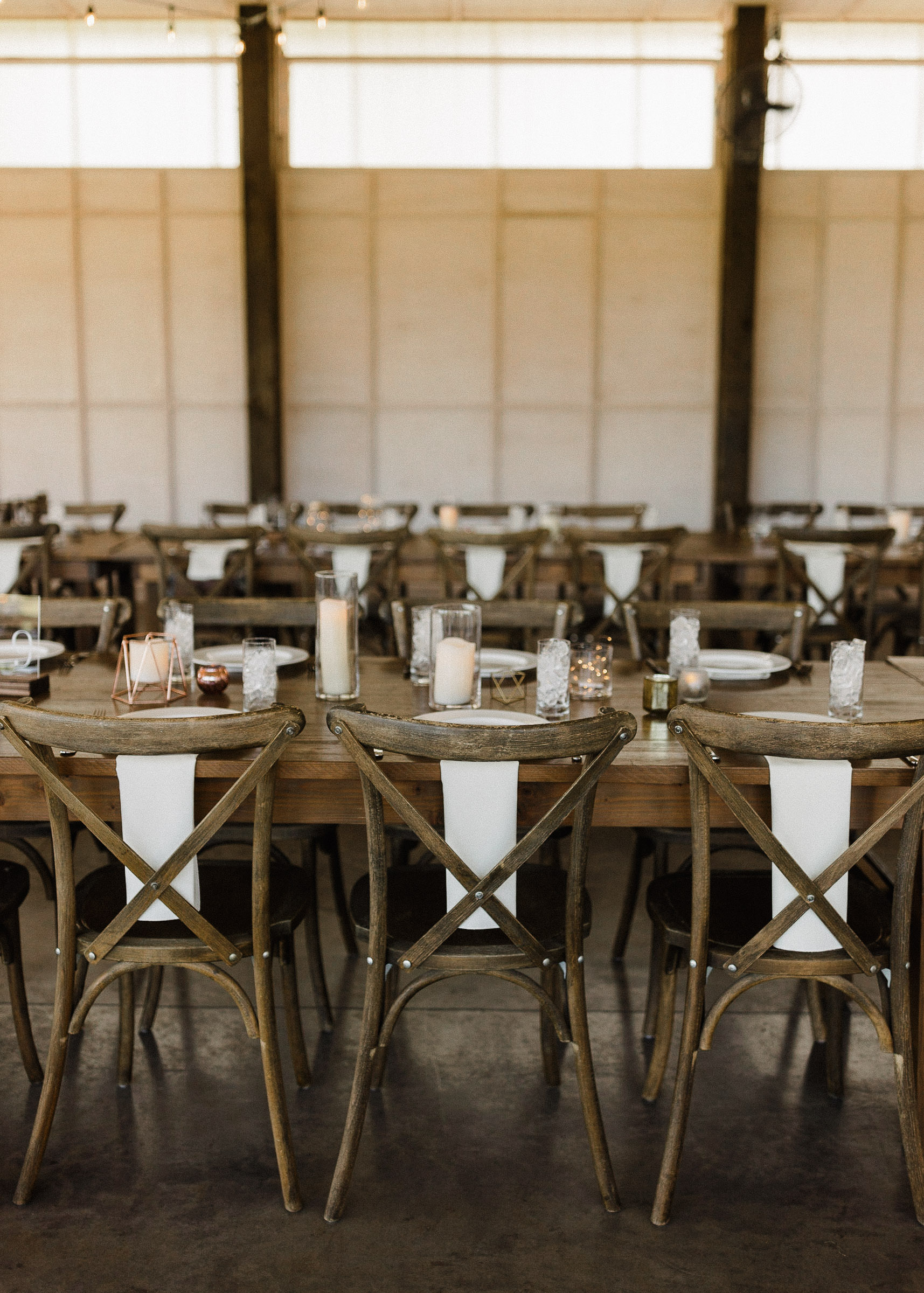 Chairs, tables, and place settings inside under semi-enclosed event space 