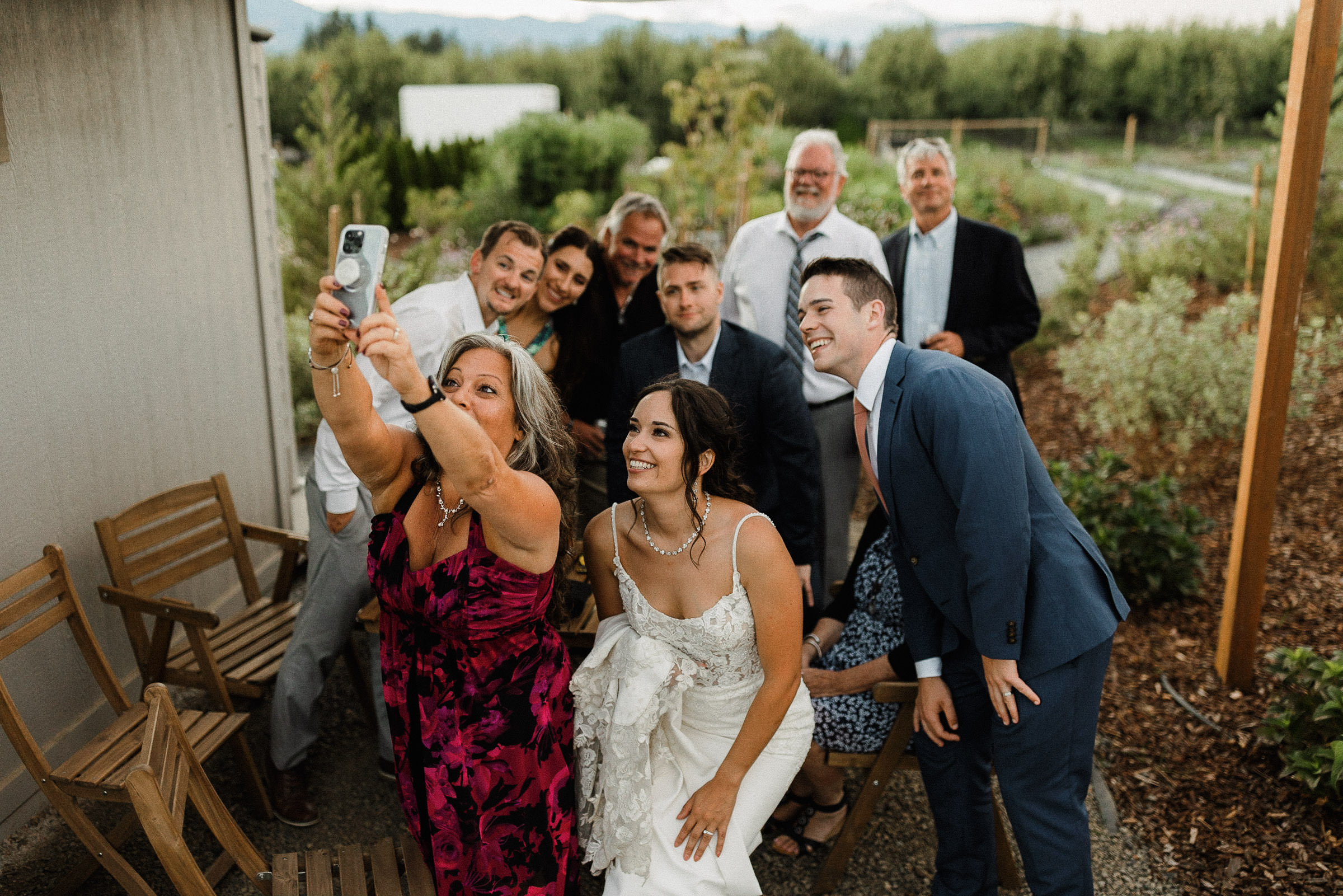Bride, groom, and seven guests squeeze together and pose for a selfie