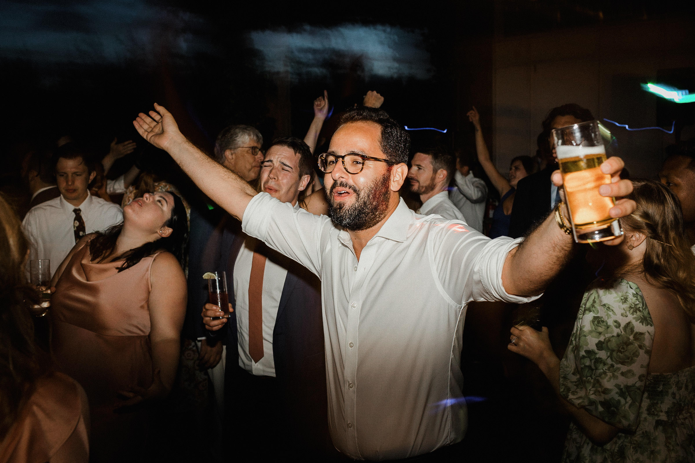Guest extends his arms wide while singing along to a song on the dance floor