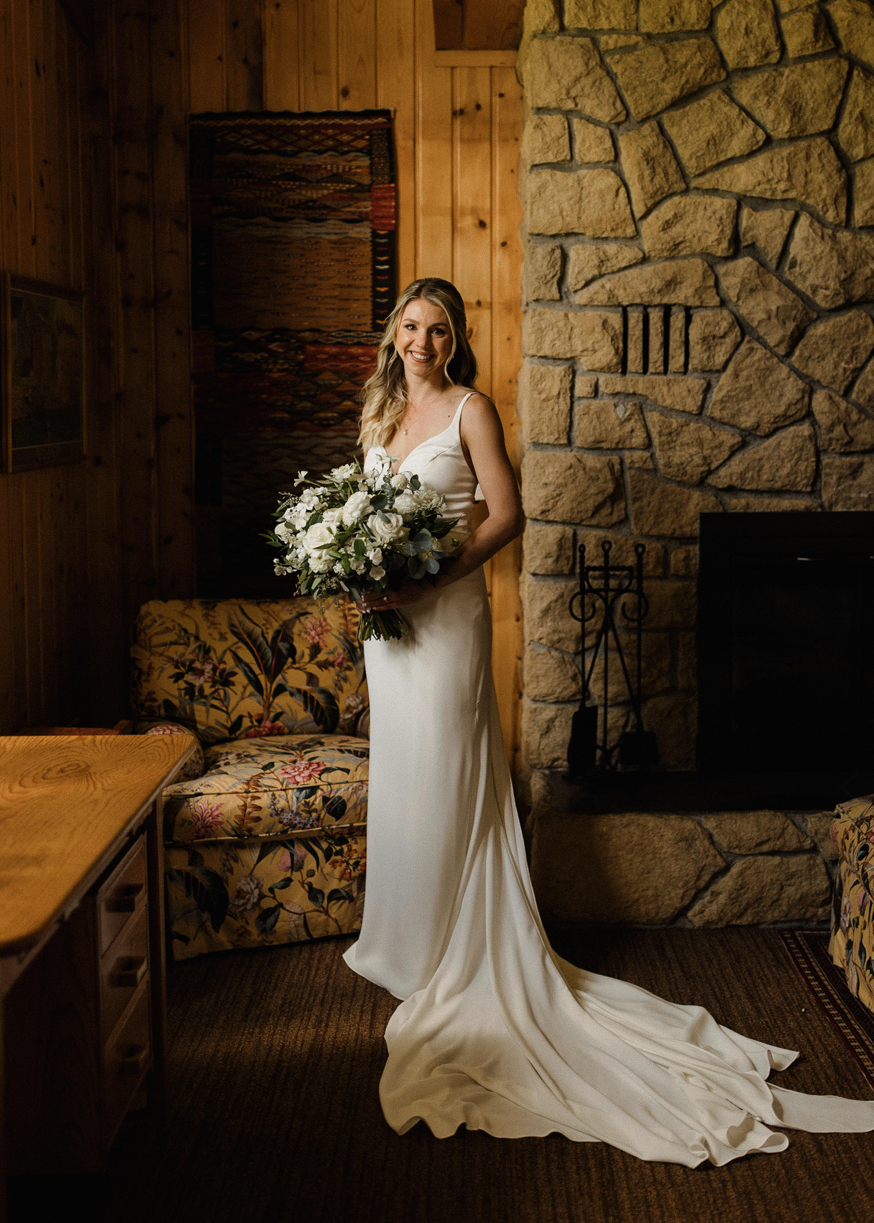 Bride poses for a portrait near a window inside the bridal suite at House on the Metolius