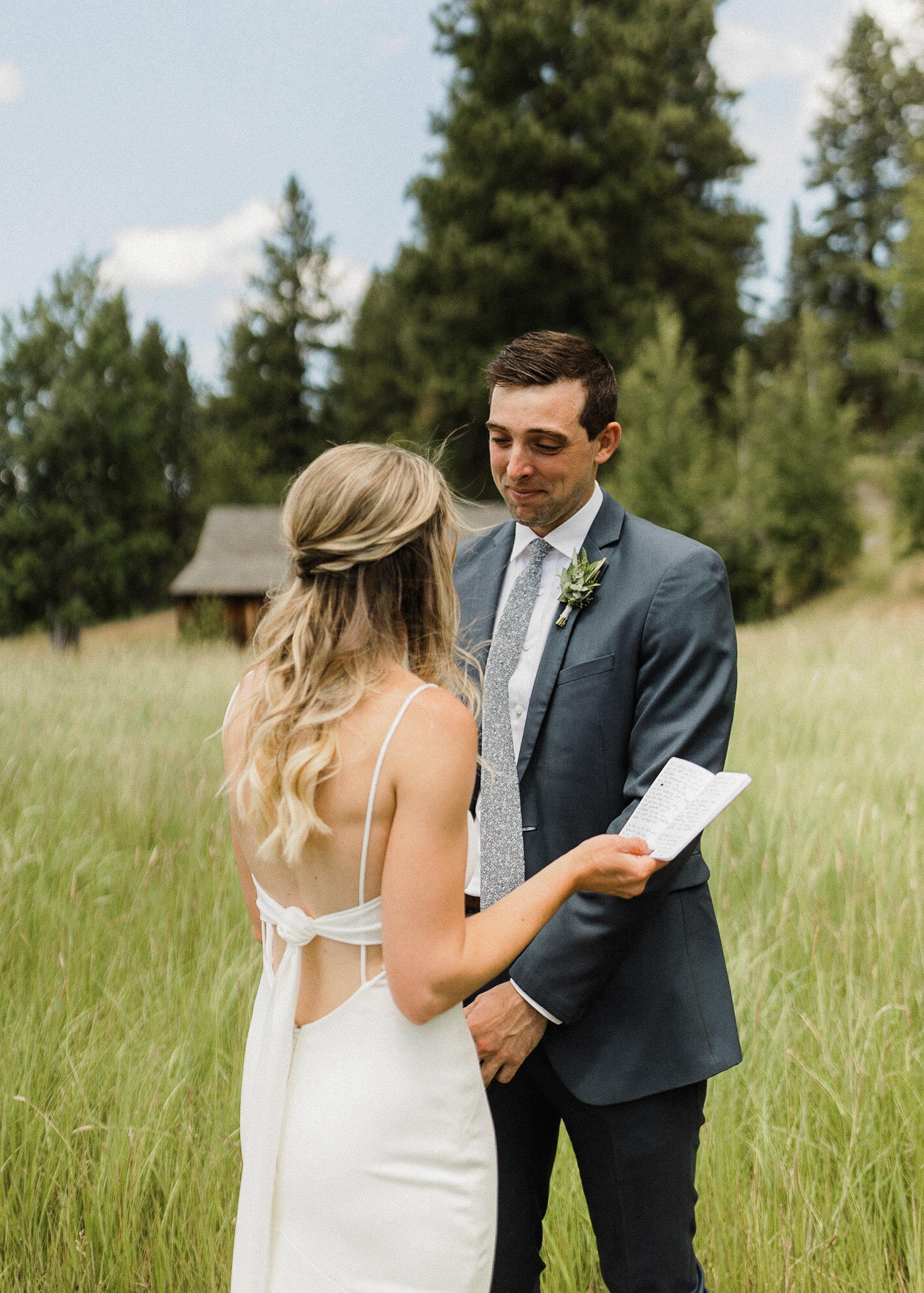 Groom reacts emotionally during a private vow reading in a field