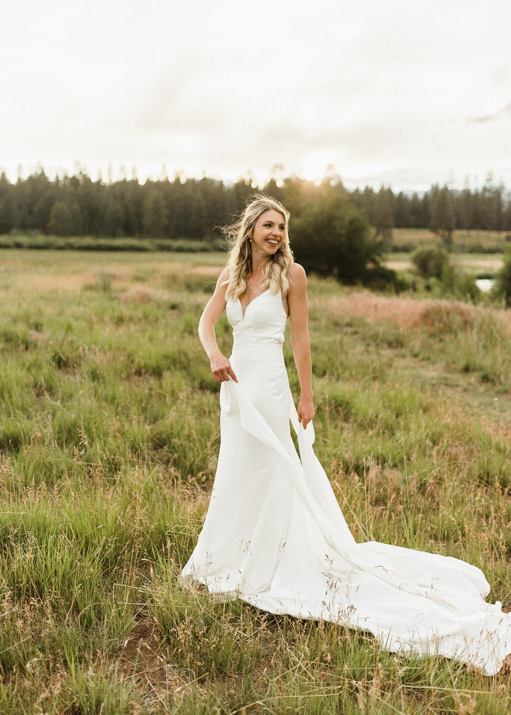 Bride poses for a portrait in a field