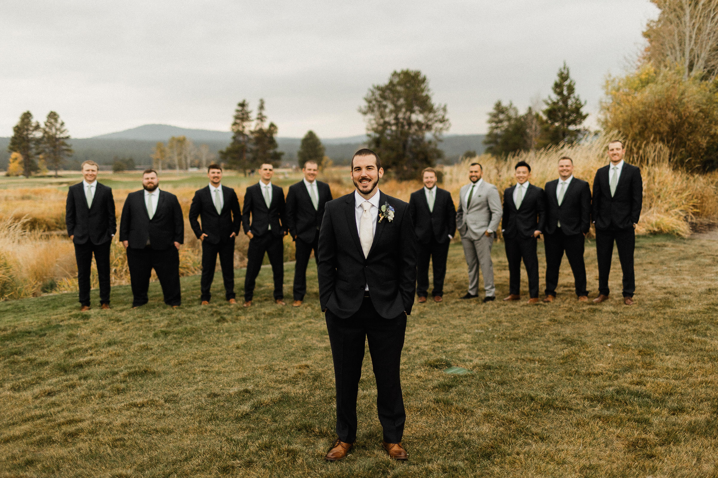 Groomsmen pose for a portrait on a lawn at Sunriver Resort