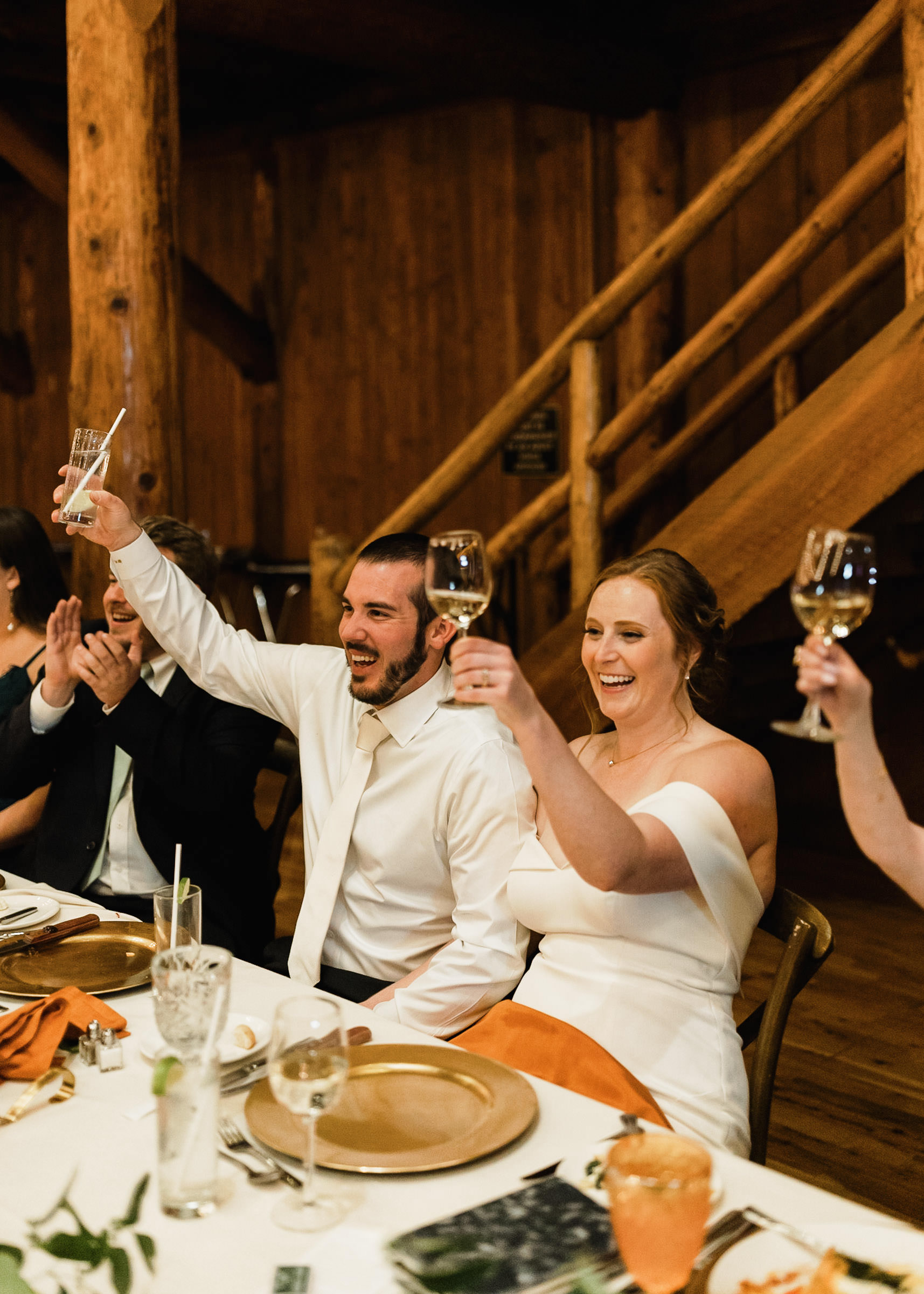 Bride and groom raise their glasses during toasts