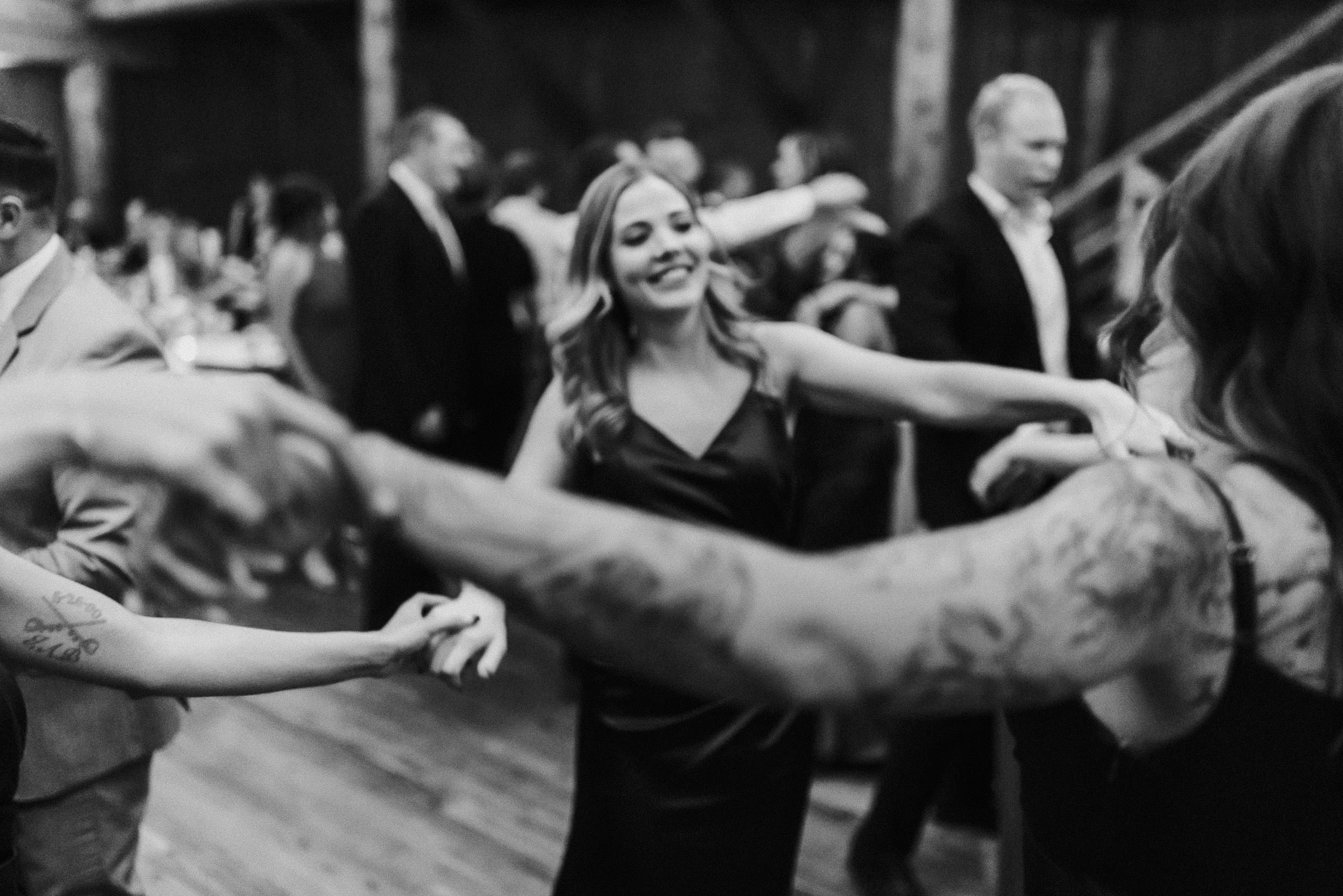 Bridesmaids hold hands and dance in a circle